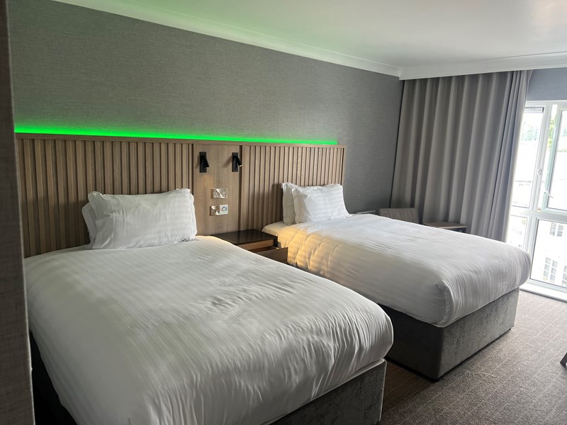 Modern bedroom with two single beds and ambient mood lighting