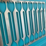 Abstract panel design with rows of curved green shapes cut into a silver metallic sheet, creating a modern, repetitive pattern.