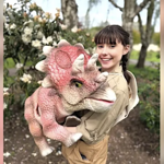 A person holding a large cuddly dinosaur.