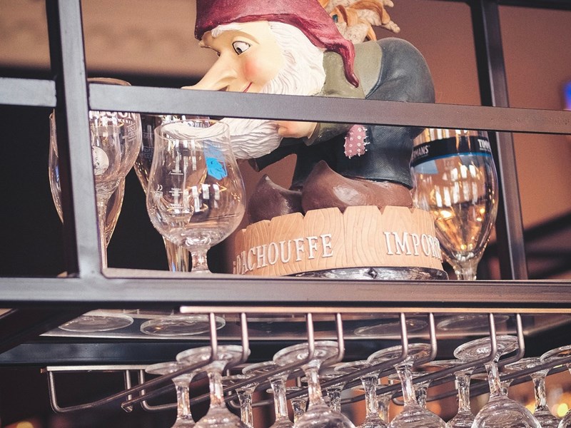 A model of a pirate hiding on am overhead glass rack, above the bar.