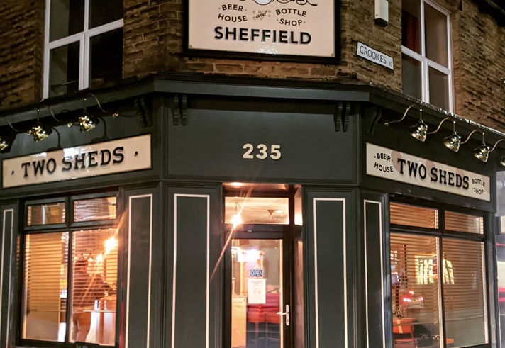 The exterior of the Two Sheds at night.
