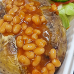 Baked potato and beans on a takeaway tray. 