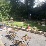 Outdoor garden of The Dalbury & Palmer Hotel featuring tables, chairs, and seating for guests.