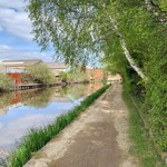 A tow path runs along the side of an inner city canal.