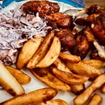 A plate of chicken in sticky BBQ sauce, chips and coleslaw at the Dog & Partridge pub.
