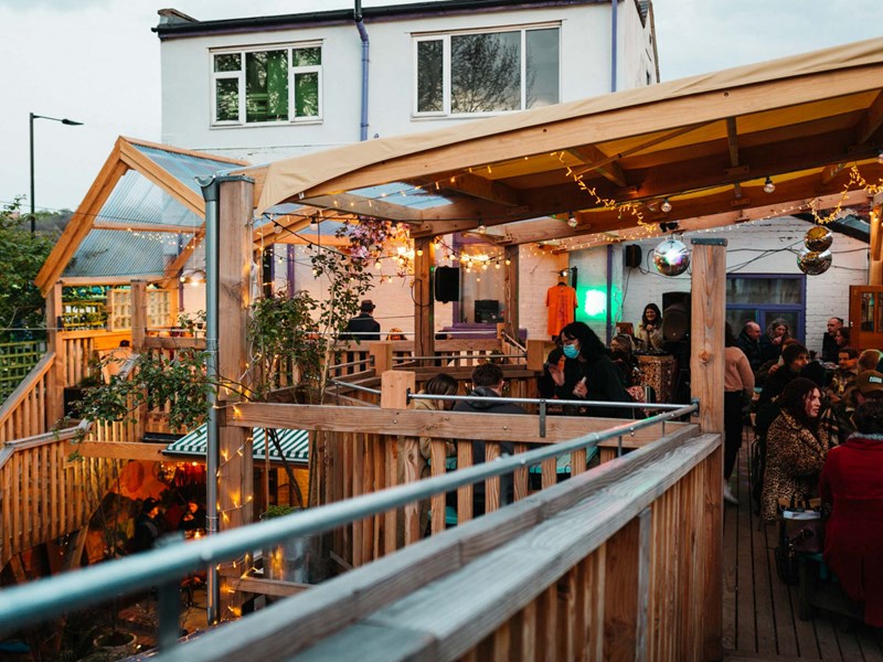 The covered balcony at Hagglers Corner, filled with people eating and drinking.