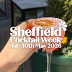 A hand holding a pink cocktail garnished with a dried orange slice in an elegant glass. The background shows outdoor seating and a large green planter with flowers. Overlaid white text reads: “Sheffield Cocktail Week, 1st – 10th May 2026” with a small flower graphic.