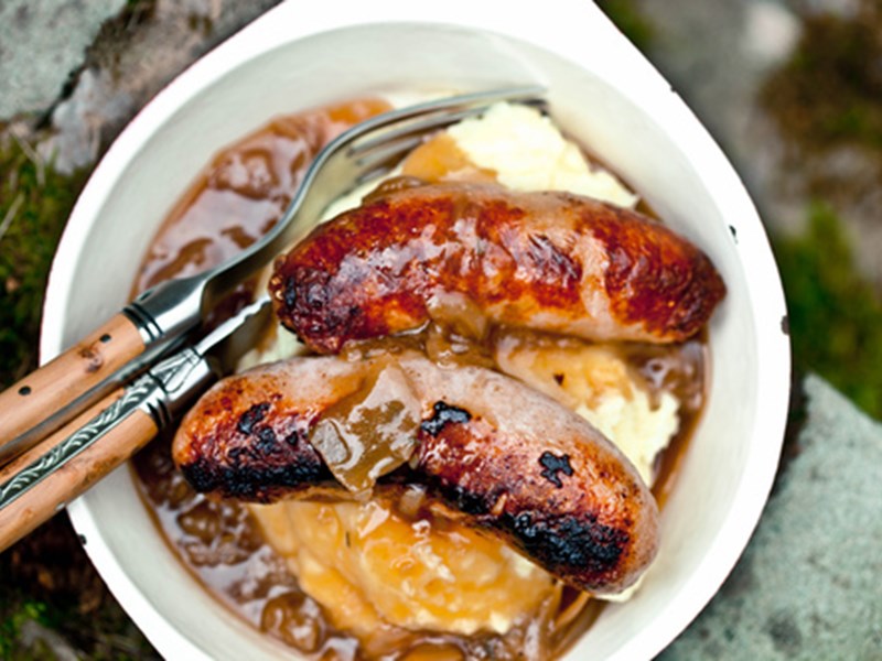 A bowl with cooked sausages in.