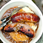 A bowl with cooked sausages in.