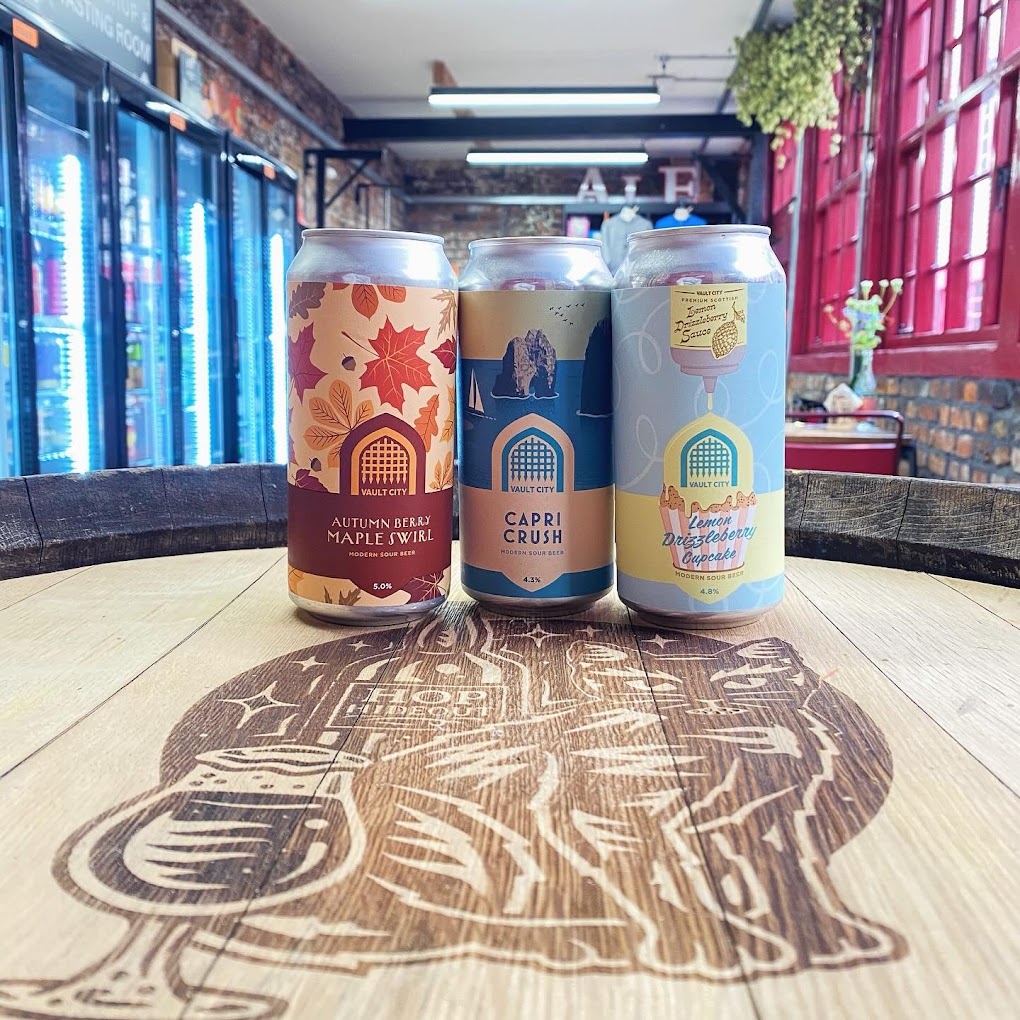 Three cans of beer on top of a beer barrel at the Hop Hideout in Leah's Yard..