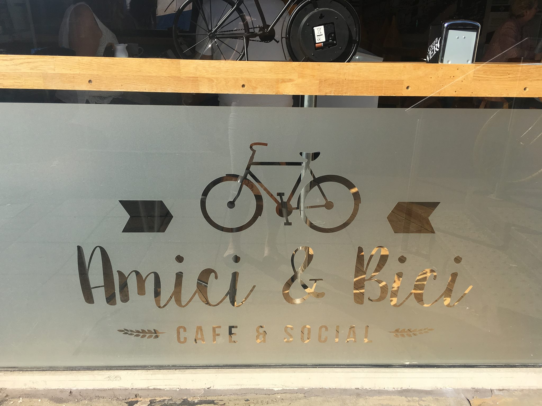 The Amici & Bici logo picked out in frosted glass on the restaurants window.