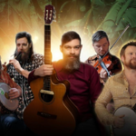 Five musicians holding instruments including two banjos, an acoustic guitar, and a violin, posed against a vibrant background with warm golden light and green tones featuring faint historical imagery.