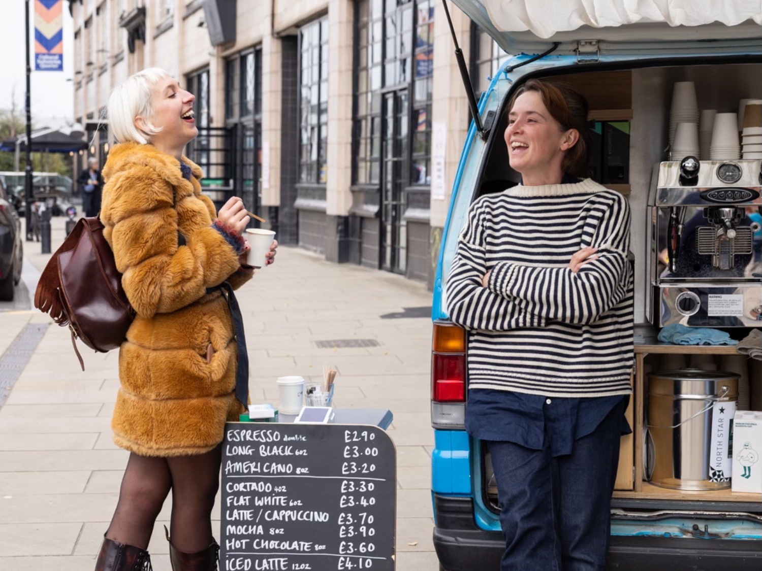 A person buying a coffee at a mobile coffee seller.
