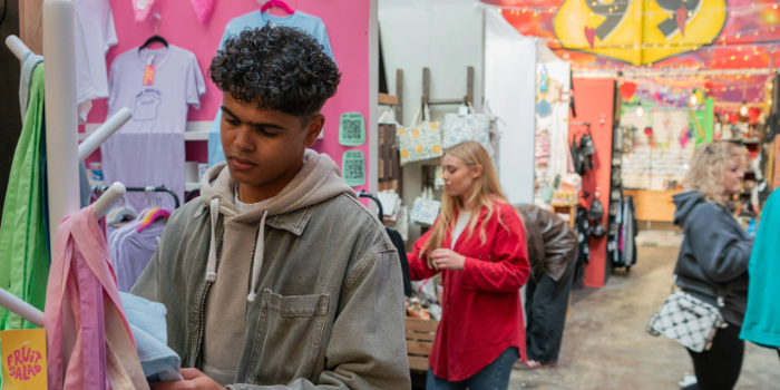 People looking at various stalls at an indoor market.