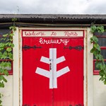 Bright red wooden double doors at The Brewery of St Mars of the Desert.