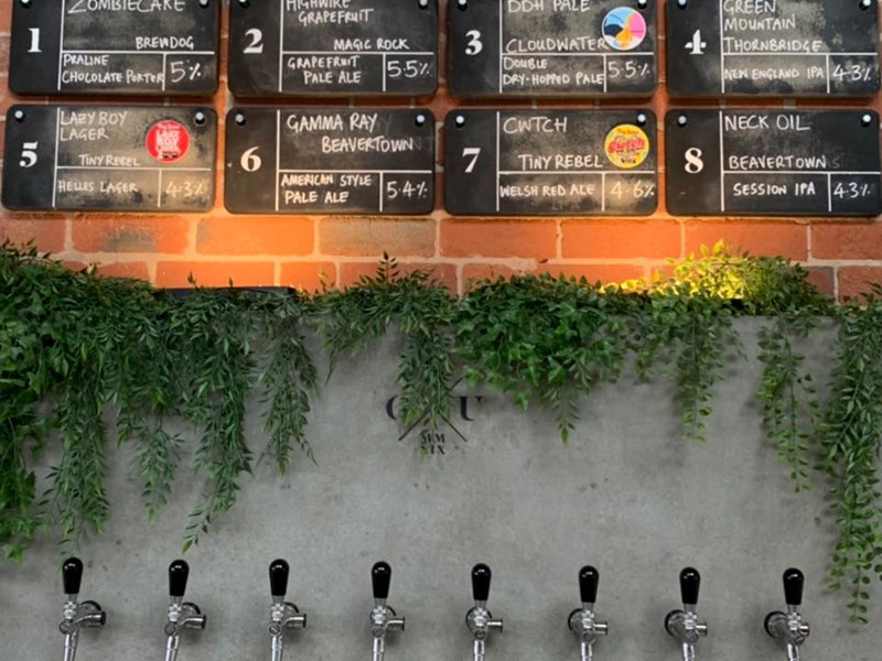 Beer pumps set into a wall behind the bar at Saw Grinders Union.