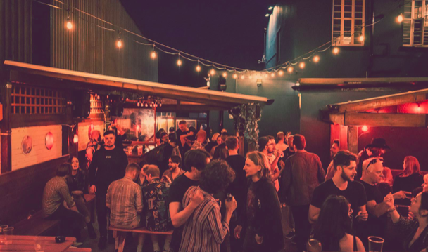 The beer garden at The Washington, filled with customers, at night.