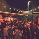 The beer garden at The Washington, filled with customers, at night.