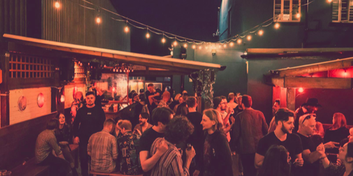 The beer garden at The Washington, filled with customers, at night.