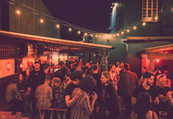 The beer garden at The Washington, filled with customers, at night.