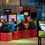 Two children and two adults sat playing vintage video games.