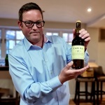 A man holding up a bottle of whiskey.