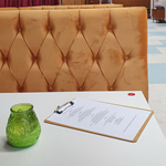 A booth at Neepsend Social Club & Canteen with a candle and a menu on the table