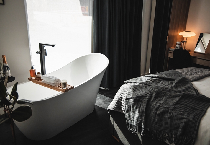A bedroom with a free standing bath.
