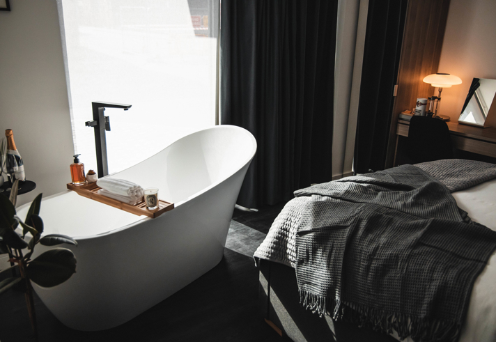 A bedroom with a free standing bath.