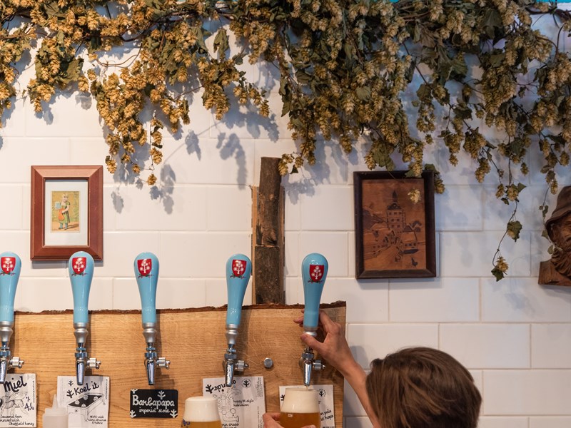 A woman pulling a pint at The Brewery of St Mars of the Desert.