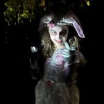 A young person in Halloween fancy dress lit with spooky lighting.