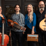 A photo of a four piece folk band, holding their instruments.