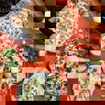 Two Neapolitan pizzas on a table, one topped with sausage and potatoes and the other with pepperoni and jalapeños, served with a Caesar salad and two glasses of beer.