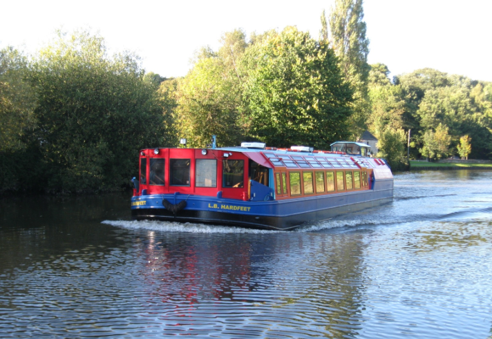 A leisure boat cruising along a canal.  