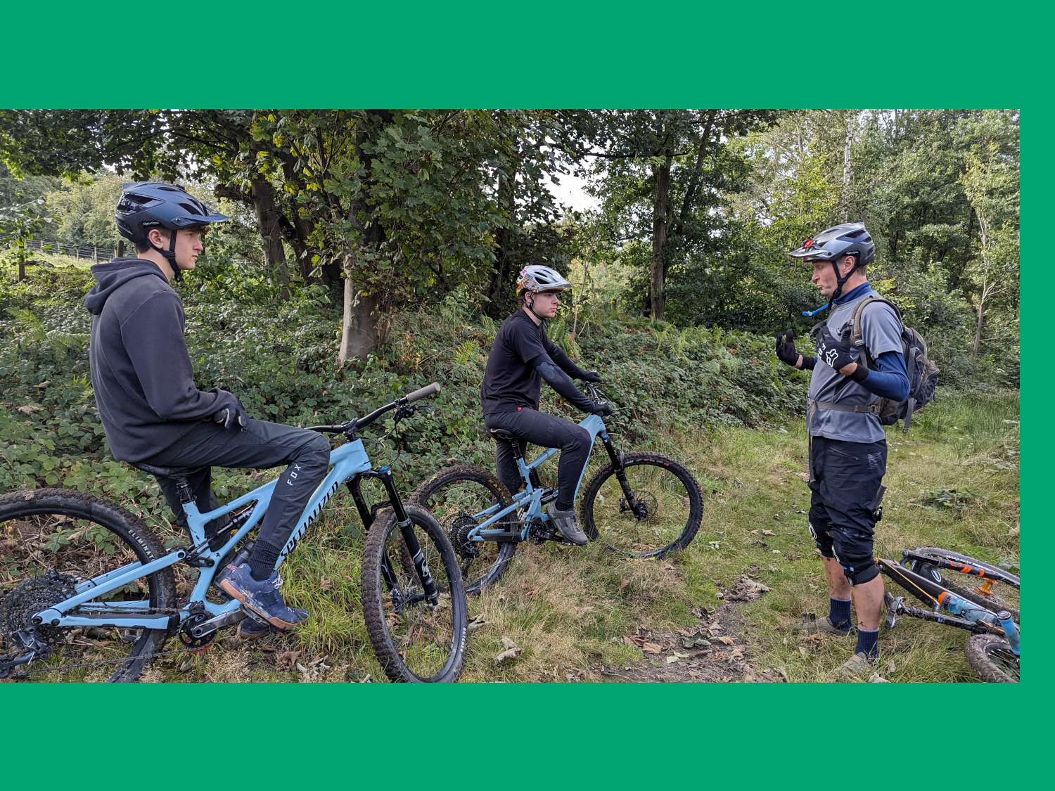 Three people mountain biking in the countryside.