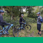 Three people mountain biking in the countryside.
