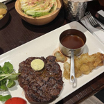 A large steak on an oblong white plate, with side dishes at Miller & Carter Steakhouse.