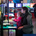 A child sits on their mothers lap, playing a video game at the National Videogame Museum in Sheffield.