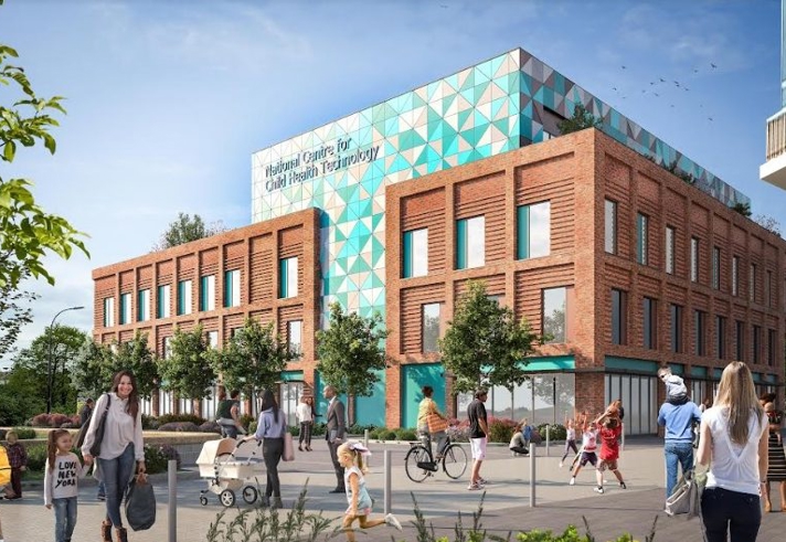 A modern building with a geometric patterned upper section in turquoise and white and a lower section made of red brick. The sign on the building reads “National Centre for Child Health Technology.” The foreground shows a pedestrian area with people walking, pushing strollers, and riding bicycles. There are trees, benches, and a clear blue sky with scattered clouds, creating a bright and welcoming urban environment.