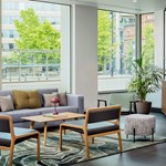 Reception area with a sofa facing a large window overlooking the outside.