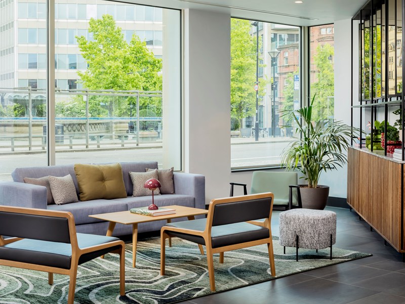 Reception area with a sofa facing a large window overlooking the outside.