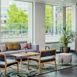 Reception area with a sofa facing a large window overlooking the outside.