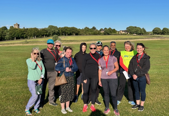 A group of people standing in a grassy field.