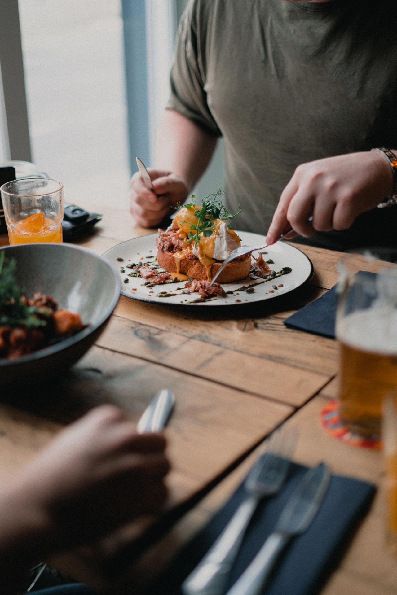 People dining at a rustic wooden table.