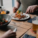 People dining at a rustic wooden table.