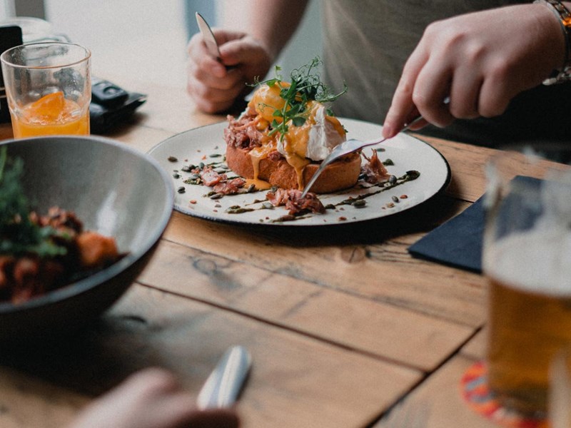 People dining at a rustic wooden table.