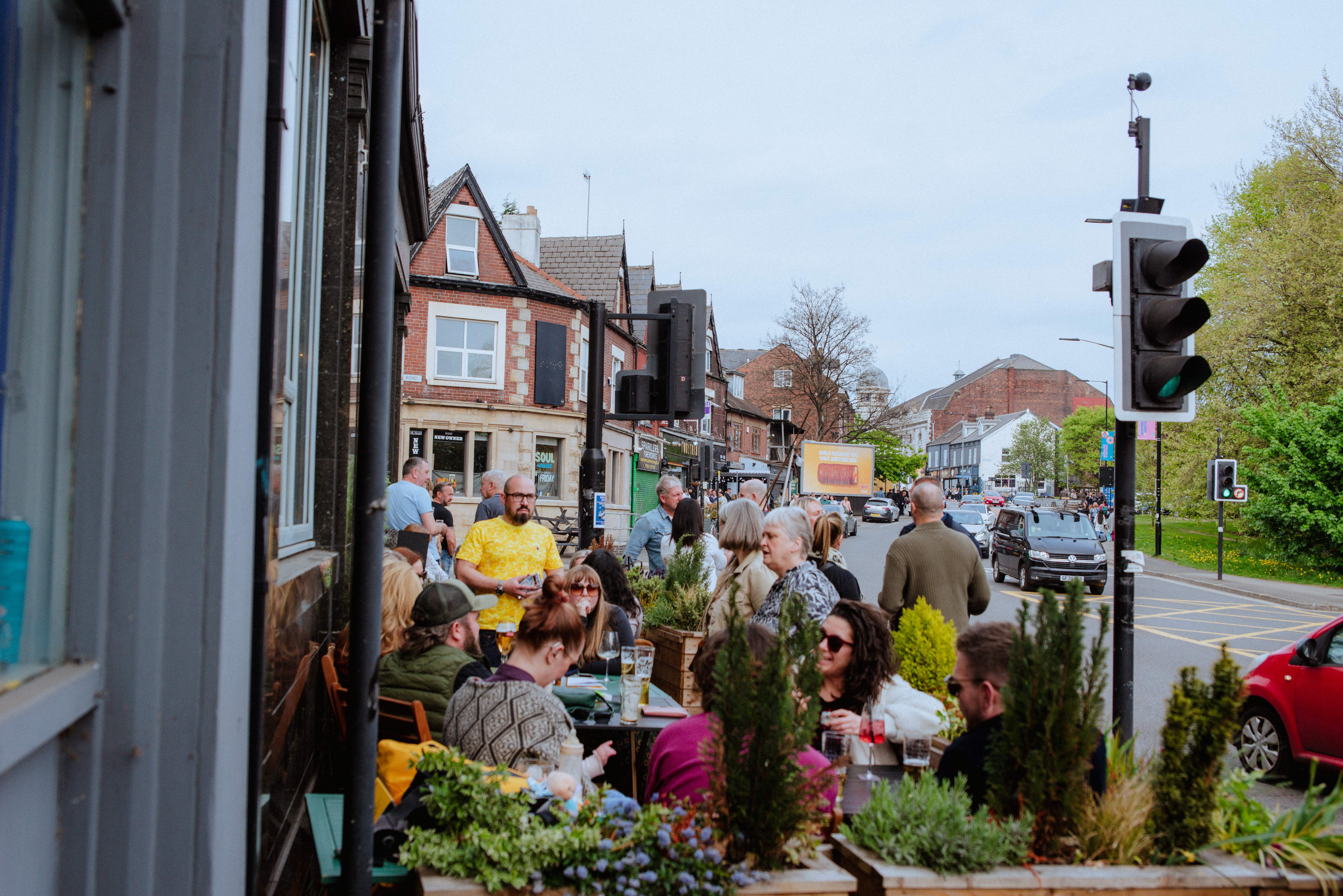 A group of happy people sat drinking outside The Gin Bar on Abbeydale Road 