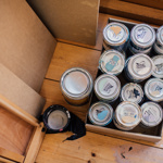 Tins of paint on a wooden floor at the Pete Mckee Gallery.