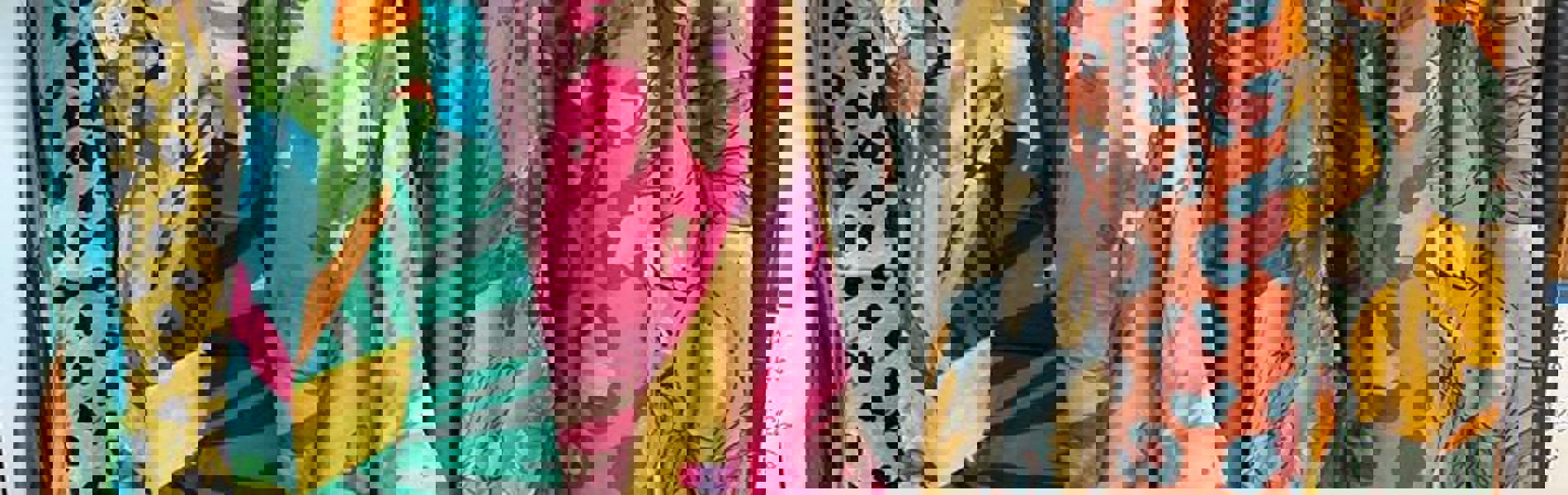 Colourful clothes hanging on a rail.