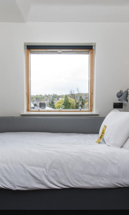 Jonas Court – bedroom with bed, bedside tables, and simple furnishings.